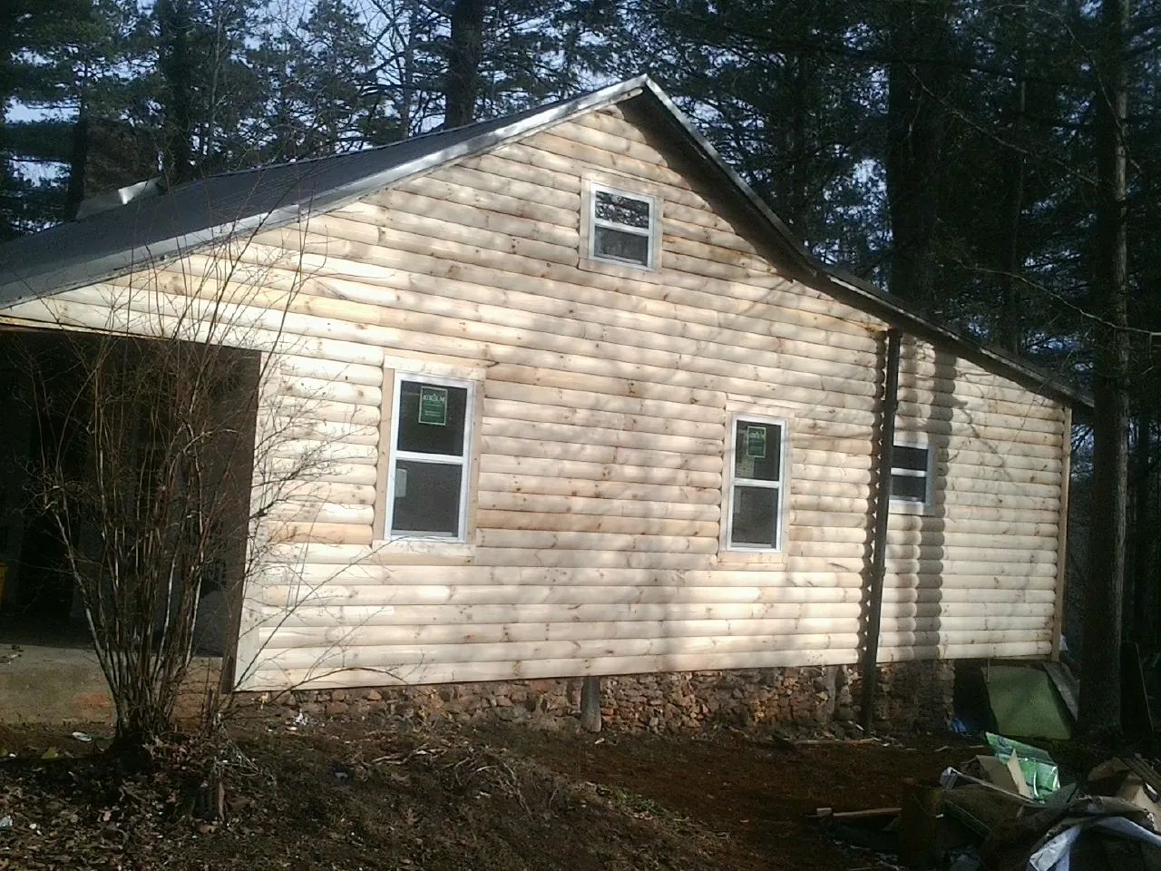 New log siding and dark metal roofing on a gable end in Joseph