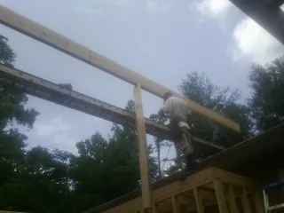 Carpenter setting a ridge beam over a new addition frame — Ice Dam Removal by Roofing Brothers in Joseph