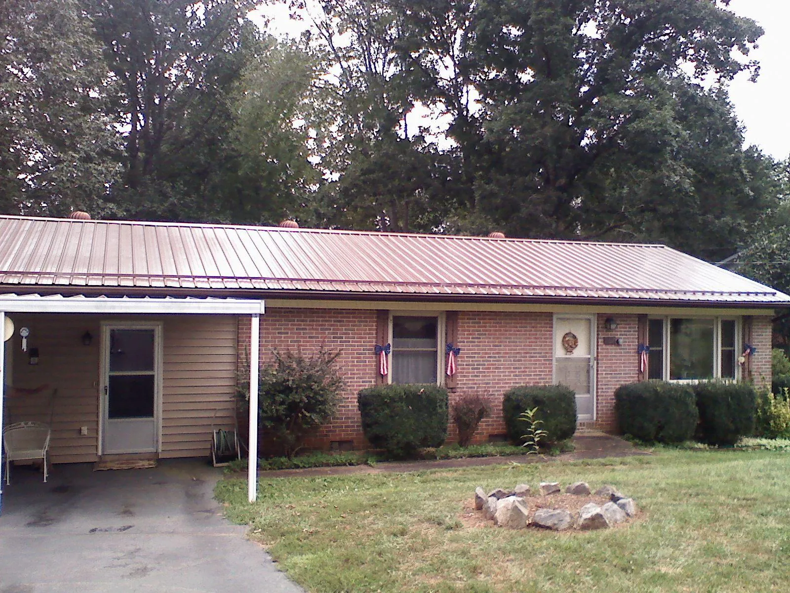 Bronze metal roof and carport on a brick ranch home — Roof Repair work by our crew in Joseph